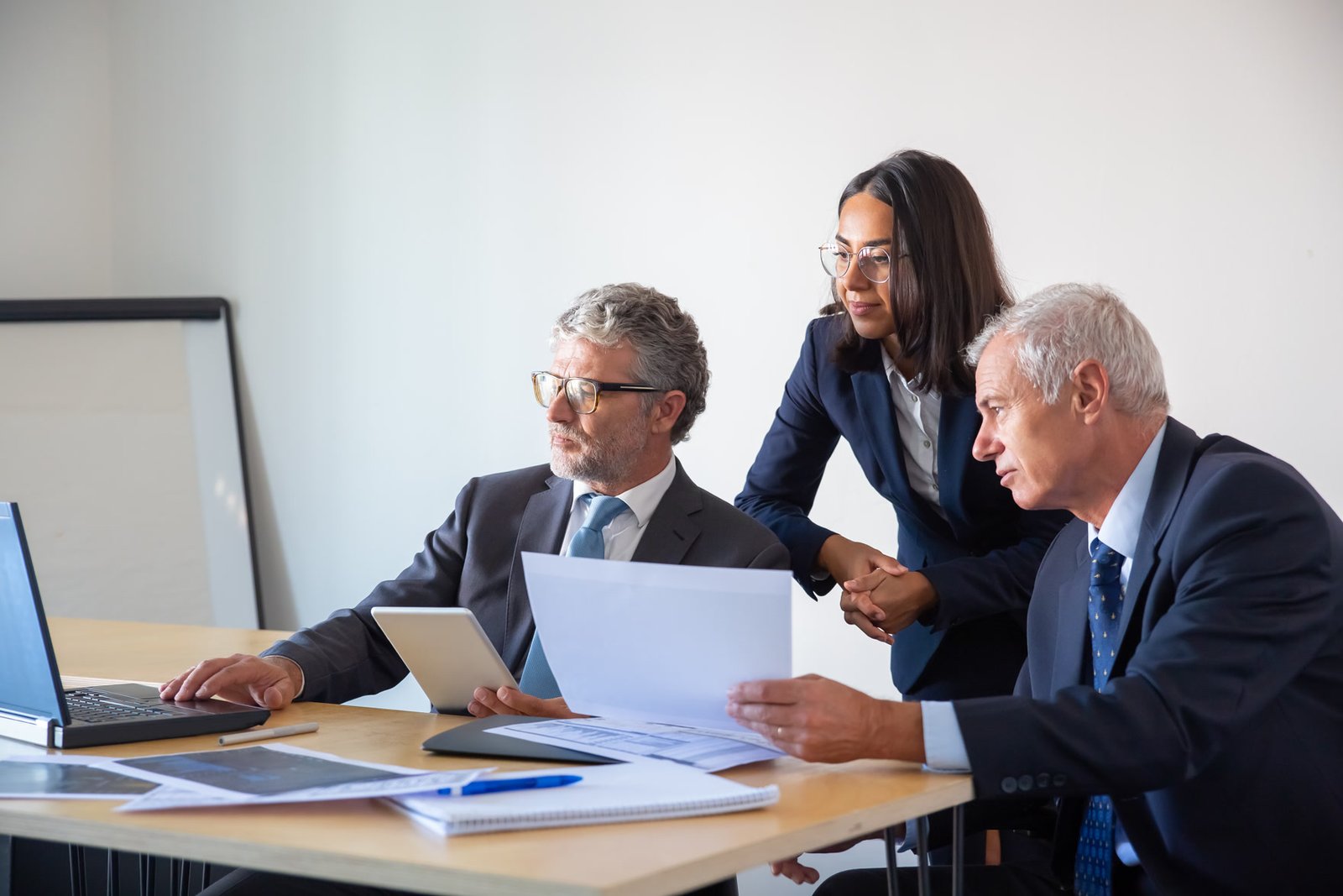 Executivos analisando documentos em uma reunião de governança