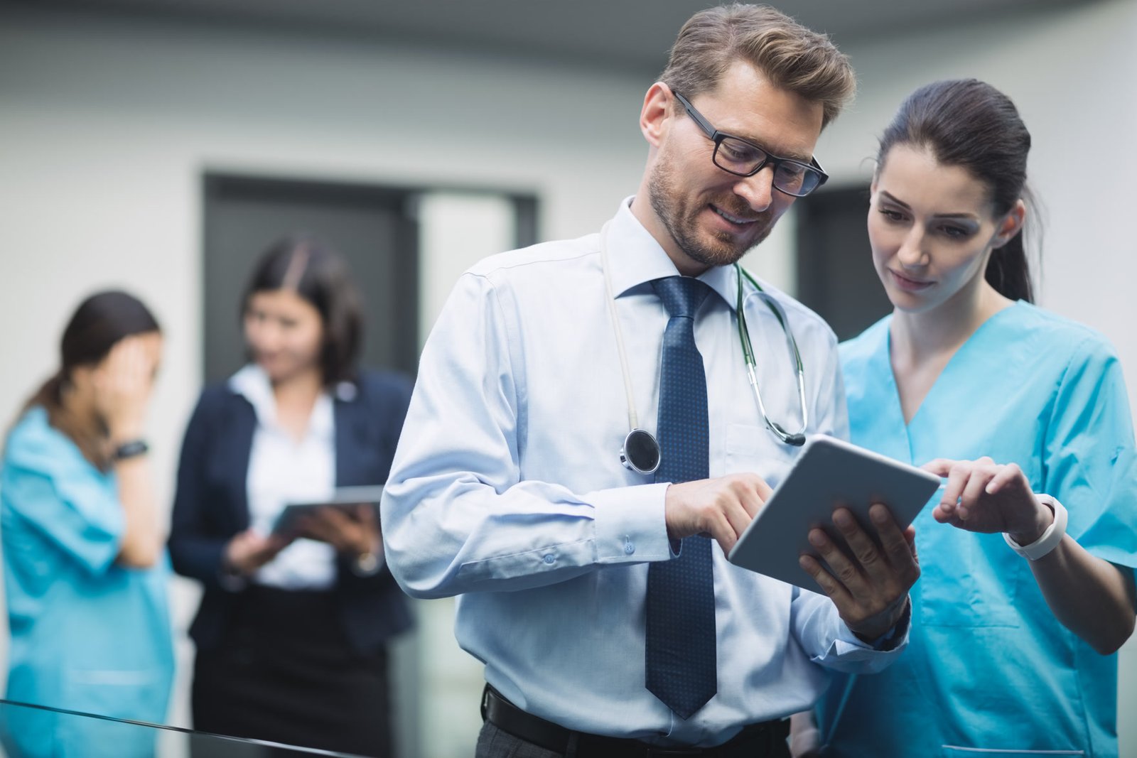 Profissionais de saúde analisando informações em um tablet